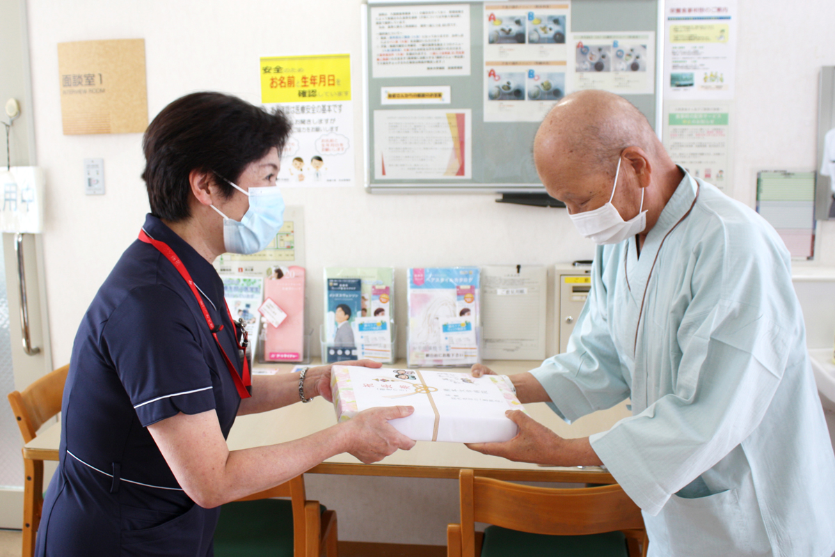 患者様へプレゼントを渡す看護部長